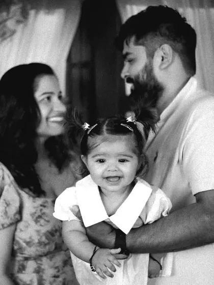A classic black and white family portrait with the baby girl smiling brightly for the camera.