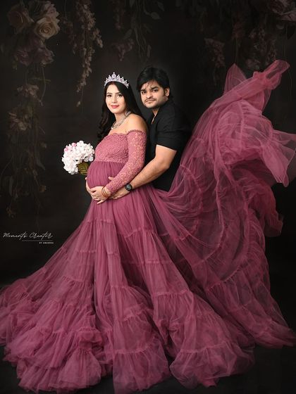 A majestic couple's portrait with a flowing gown. The fabric toss adds a sense of drama and movement, making the mom-to-be look like a queen.
