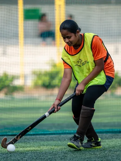 Focus and determination in action. Here, a young camper practices her dribbling, showcasing the individual attention and skill development that is core to our coaching philosophy. We help every player master the fundamentals of hockey.