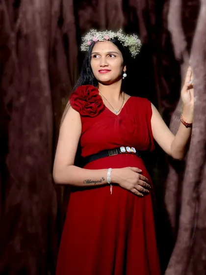 A beautiful solo maternity portrait. This simple red gown is accessorized with a floral hairpiece and a statement belt, showing how you can personalize your look.