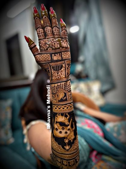 A full view of a stunning bridal back hand design. The arm is covered in intricate details, including a large portrait of a cow and calf.