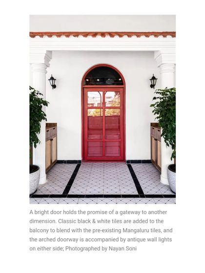 A bright red door promises entry into a new dimension. I used classic black and white tiles on the balcony to blend with the pre-existing Mangaluru tiles, creating a striking and welcoming entrance.