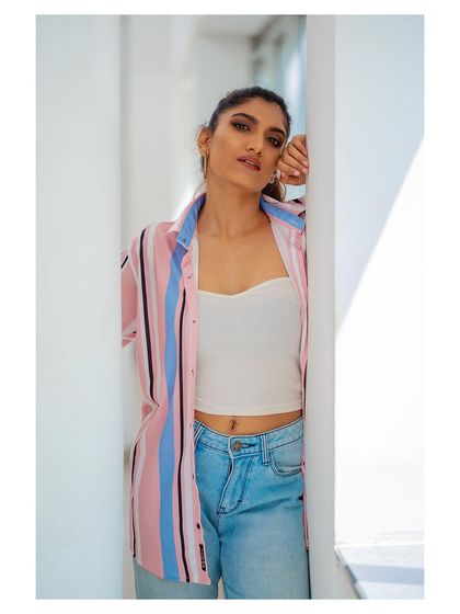 A casual outdoor portrait. The striped shirt and jeans create a relaxed, approachable look, perfect for lifestyle photography.