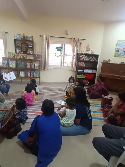 A full view of our cozy library during a story session. You can see how children and parents gather together in a relaxed, comfortable setting, creating a warm community atmosphere for learning.