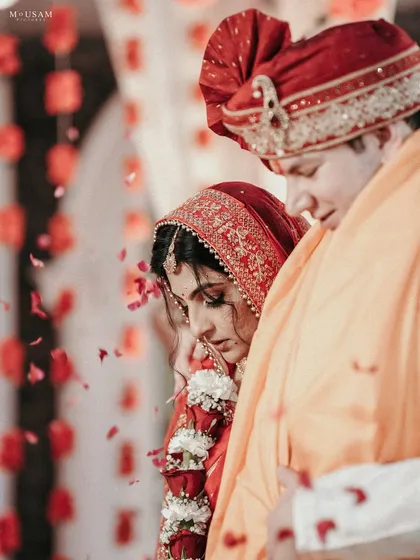 The seven sacred steps, or Saptapadi. This intimate, emotional shot captures the bride and groom during the pheras, with a shower of petals adding to the poetry of the moment. It’s a frame that signifies their journey together.