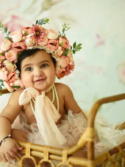 Milestone sessions are a wonderful way to document your baby's growth. This six-month sitter session captures that adorable stage where your baby can sit up and show off their budding personality. I have a variety of cute props, like this floral bonnet, to style the shoot.