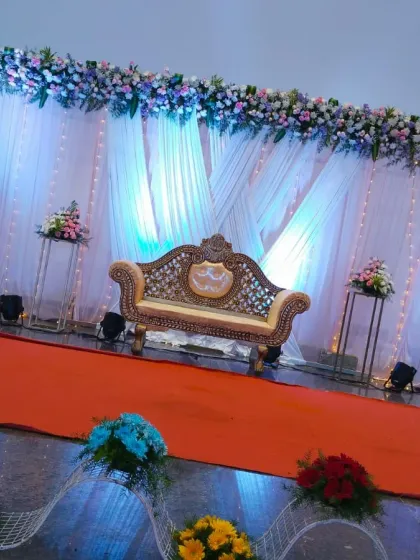 A slightly different angle of the reception stage, capturing the shimmer of the fairy lights and the texture of the draped backdrop.