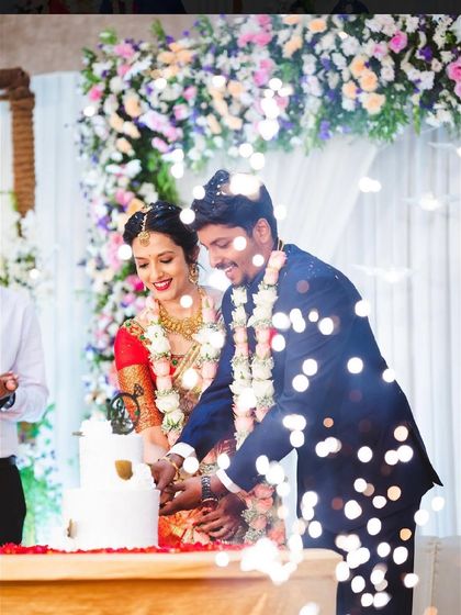 A magical shot of a couple cutting their engagement cake, with sparklers and lights adding to the celebratory moment.