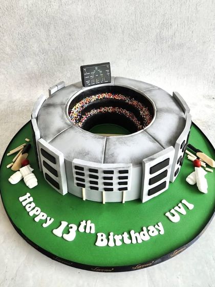 A cricket stadium cake for Uvi's 13th birthday. We recreated the stadium structure, with the centre filled with sprinkles to look like a cheering crowd.