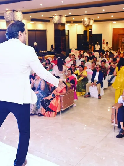 From the stage to the audience, I make sure to engage with everyone. Here I am getting the guests seated in the front rows involved in the fun.