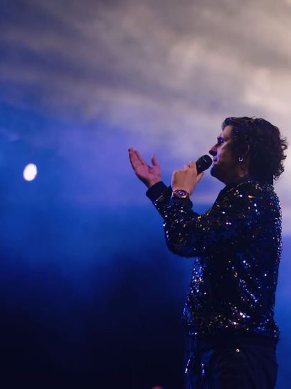 Sonu Nigam bathed in a mix of blue and white light, creating a serene and powerful image. This shot captures the more melodic and soulful side of his performance.