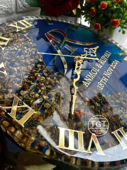 An angled shot of the navy blue resin clock, highlighting the reflection on the surface and the texture of the preserved flower buds.