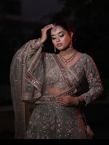 A graceful pose showing the details of the blouse and dupatta of our grey and pink embroidered lehenga.