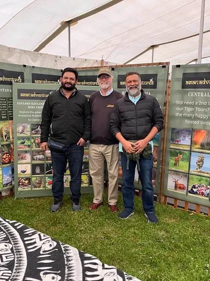 Three of our core team members in front of our tour display panels at the Global Birdfair. These panels give a glimpse into the vast array of experiences we offer.