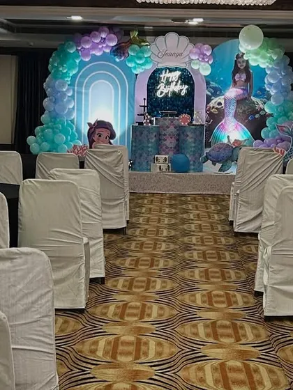A view of the banquet hall prepared for a mermaid-themed party, with the main stage visible in the background.