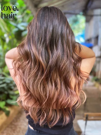 We call this look "blush." A beautiful rose gold balayage with soft pink and brown tones that create a romantic and trendy style.