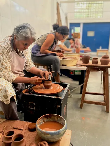This is the beautiful energy of our studio. Students of all ages and backgrounds, deeply focused on their work, learning to trim their pieces on the wheel. It's a space for quiet concentration, shared learning, and the simple joy of making.