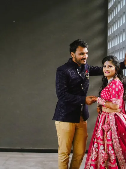 A full-length view of this beautiful couple. The contrast between the bright pink lehenga and the dark blue Jodhpuri suit is simply perfect for an engagement or wedding.
