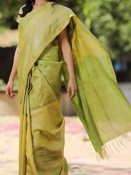 This Genda Phool Kosa Silk Saree in shades of green and yellow has a light, airy feel. The handloom weave gives it a unique texture and a graceful fall.