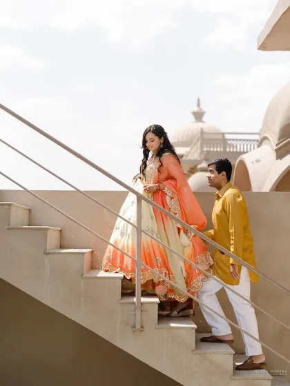 Ascending the stairs together. This simple, elegant shot symbolizes the couple's journey forward, captured with beautiful natural light against the palace architecture.