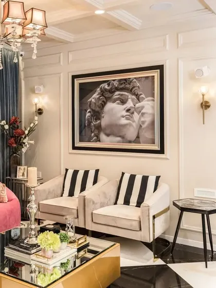 An art-filled modern living room where classic and contemporary styles meet. The bold artwork and checkerboard floor are balanced by the elegant lines of the furniture and sophisticated wall paneling.