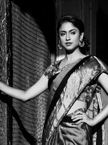 A timeless black and white portrait of a model in a traditional silk saree, using dramatic lighting to create a classic, cinematic feel.