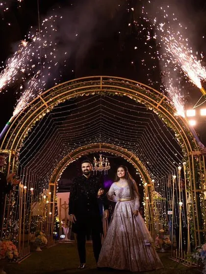 The couple's grand reception entrance through a tunnel of sparklers held by their friends and family. It's a magical, high-energy moment that kicks off the party perfectly.