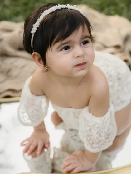 A close-up of a baby girl interacting with her reflection. Her curious expression is absolutely adorable.