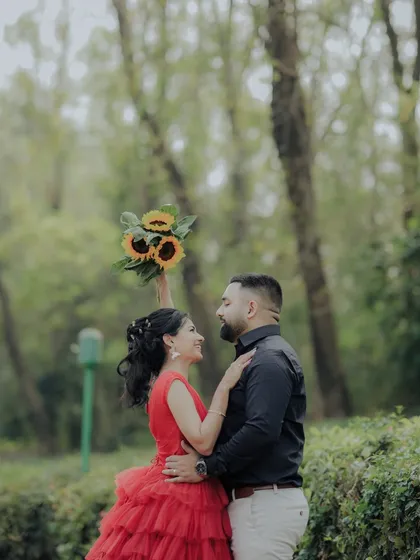 A romantic gaze shared between the couple in a serene garden setting. The sunflowers add a pop of cheerful color, symbolizing adoration and loyalty in this beautiful pre-wedding photograph.
