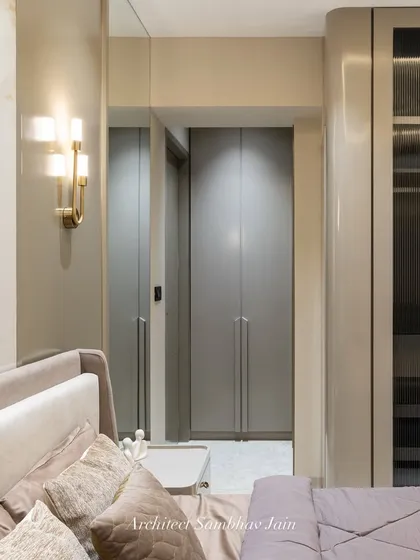 This sophisticated grey-themed bedroom exudes quiet luxury through its tonal harmony. The centerpiece is the sleek wardrobe crafted in a blend of PU finish and fluted glass, an elegant pairing that adds texture and depth.