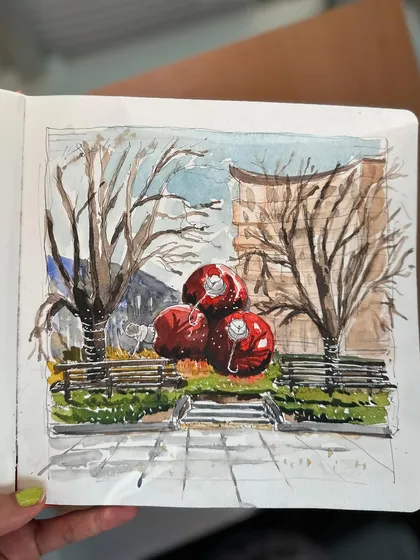 A close-up of my festive watercolour sketch, capturing the giant red Christmas ornaments and the bare winter trees.