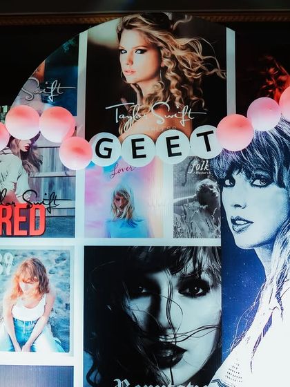 A super cool Taylor Swift "Eras Tour" themed party for a 13th birthday. The backdrop is a collage of Taylor's album covers, complete with vinyl record props and microphone cutouts.