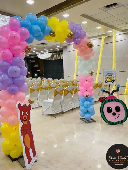 A Cocomelon-themed entrance arch for a first birthday party. The colorful pastel balloons and character cutouts create a cheerful welcome for all the guests.