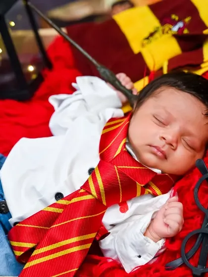 The perfect shot for fans, this newborn is styled as Harry Potter, complete with a Gryffindor scarf, glasses, and a wand.