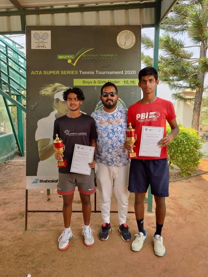 A coach with the doubles finalists, a proud moment recognizing the hard work of these young athletes.