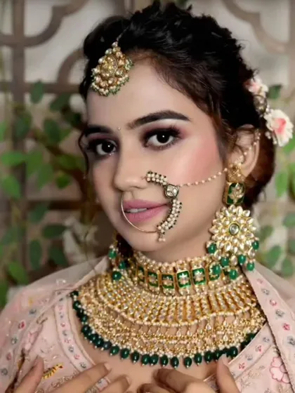 A bride wearing a green and gold Kundan set with a simple pink lehenga. This shows how you can mix and match colors for a beautiful result.