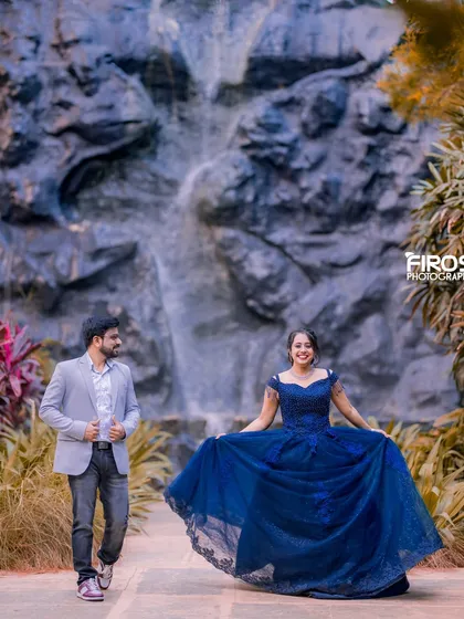 A happy and candid moment in front of the waterfall, with the flowing blue dress adding a touch of elegance.
