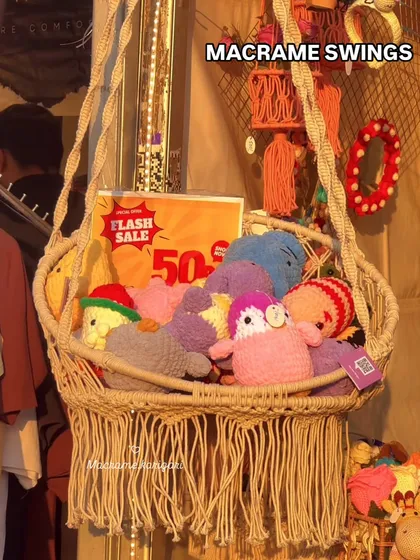 Our handmade macramé swing chair, filled with crochet toys at an exhibition. This is a functional piece of art that adds a cozy and playful nook to any room.