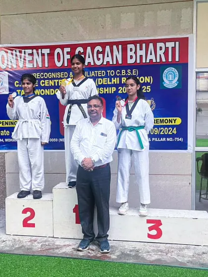My female students celebrating their victories on the podium at the CBSE Central Zone Taekwondo Championship.