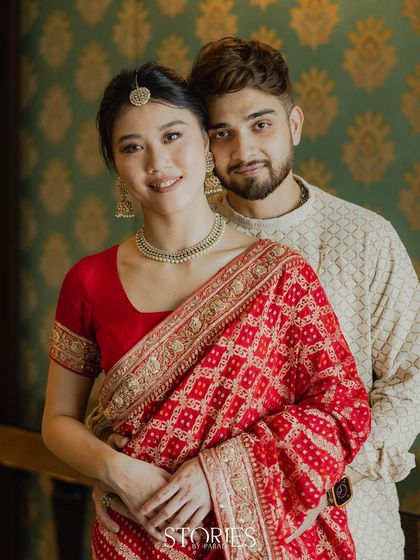 A classic portrait of the influencer couple against an elegant, patterned wall. Their coordinated outfits and serene expressions create a picture of timeless grace and togetherness.