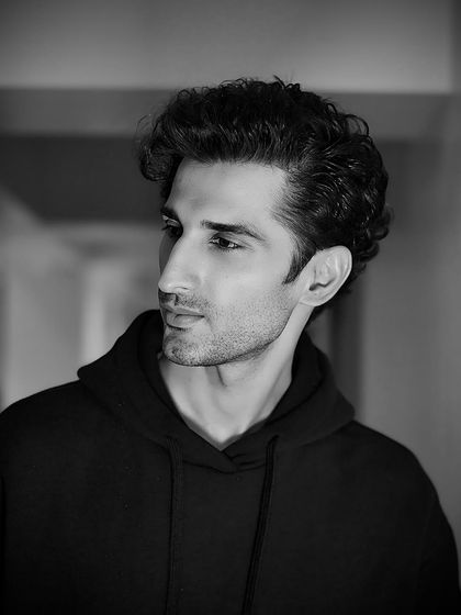 A handsome black and white portrait of actor Sidhant Gupta, with his curly hair expertly styled for a soft, natural look.