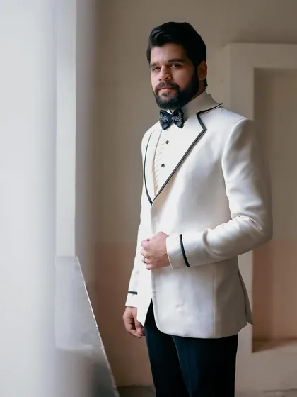 A classic, confident portrait of Kshitish Date in the white tuxedo.