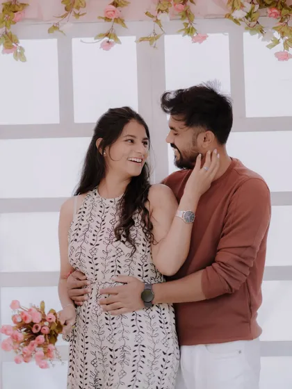 A tender moment against a romantic floral backdrop. The soft pink tones and the couple's gentle embrace create a dreamy and affectionate pre-wedding portrait.
