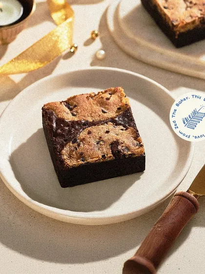 Our Cookie Dough Brownie is a festive favorite. This decadent treat, featuring a fudgy brownie base topped with crunchy cookie crumble, was a highlight of my Diwali gift collection.