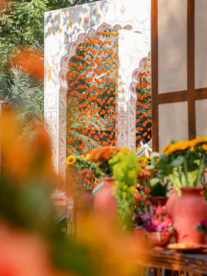A view of the Mughal arch entrance as seen from the dining area, with the vibrant floral tablescapes in the foreground. This shot shows how different zones of the event were visually connected.