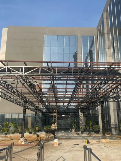 Work in progress at Heritage Xperiential School. This image shows the structural framework of the entrance canopy, offering a glimpse of the building's skeleton before the final layers are applied.
