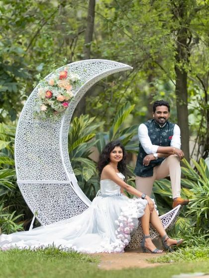 A whimsical and romantic pre-wedding photo. The client's unique high-low gown with floral details is perfectly complemented by her partner's stylish Nehru jacket.
