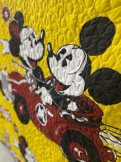 A close-up of Mickey and Minnie, showing the stippling quilting pattern.