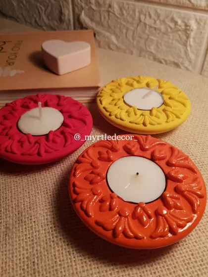 Three of our festive diya holders with tea lights inside. The bright yellow, orange, and pink colors are perfect for bringing a joyful, celebratory feel to your home.