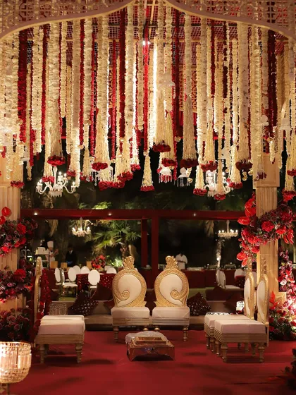 The classic red wedding, reimagined. This grand mandap features a ceiling of cascading red and white florals, creating a rich, luxurious, and deeply traditional setting for the wedding ceremony.